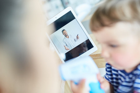 Pediatrician gives online advice to sick child in video chat via tablet computer