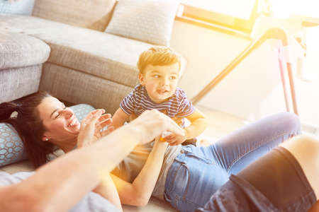 Happy family with child lies in the living room to relaxの写真素材