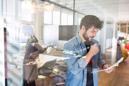 Young business start-up man starting a business reads a document in his office