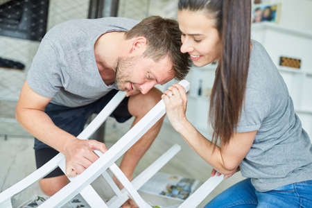Young couple as do-it-yourselfers to refurbish and paint a chair as upcyclingの写真素材