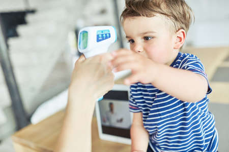 Child measuring a fever in medicine Online consultation via video chatの写真素材