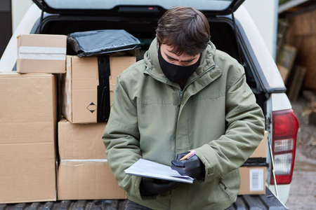 Parcel service subcontractor brings parcels in the car with face mask because of Covid-19 for Christmasの写真素材