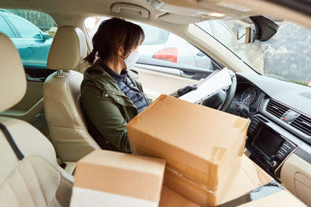 Parcel deliverer with face mask because of Covid-19 brings delivery for Christmas