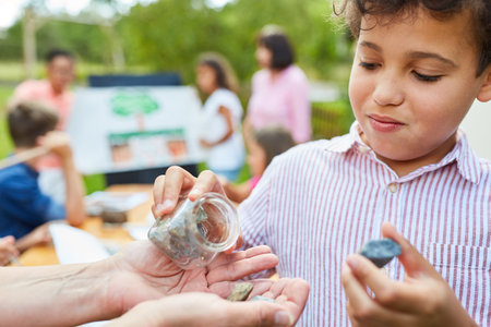 Child in the summer tuition course in natural history learns about rock and natural scienceの写真素材
