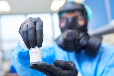 Researcher in the laboratory with Covid-19 vaccine in a small ampoule