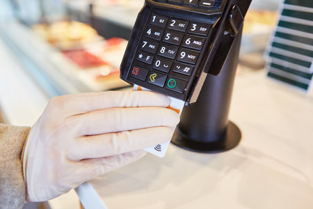 Hand in disposable gloves because of pandemic paid by credit card at the checkout