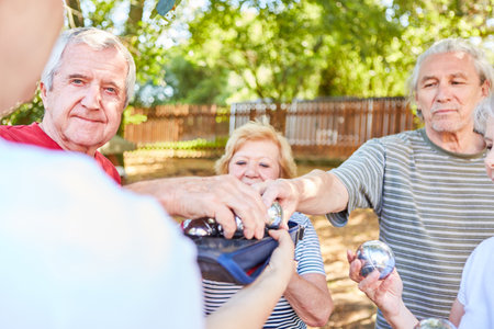 Seniors as a sporty pensioner team playing boules in a competitionの写真素材