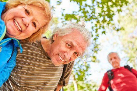 Happy senior retired couple on a hike in nature in summer