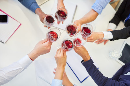 Group of business people toasting with red wine in a meeting as alcohol conceptの写真素材