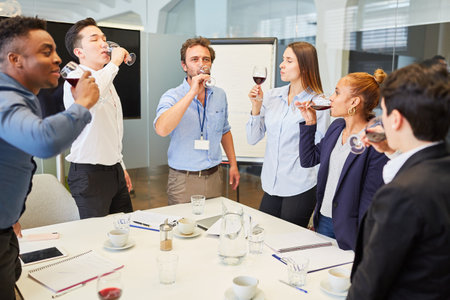 Group of business people drinking a glass of red wine at a company party in the office