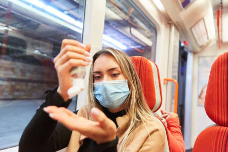 Passenger with mask when disinfecting hands in local transport due to virus  pandemicの写真素材