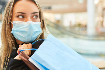 Woman as a customer shopping in the shopping center with face mask because of the pandemic