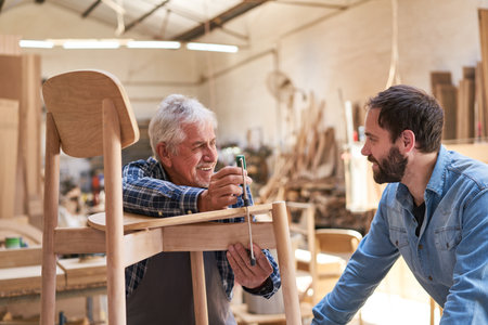 Craftsmen Masters and cabinet makers in training at gluing chairsの写真素材