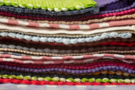 Colorful piles of different fabrics and tablecloths stacked on top of each other