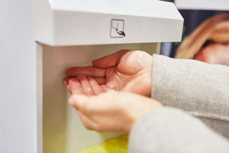 Customer at the hand disinfection in the supermarket because of Covid-19 pandemicの写真素材