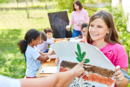 Girl in summer camp for ecology and nature conservation with the drawing of a plantの写真素材