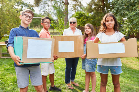 Group of children as voluntary helpers in fundraising campaign collect donations and old clothesの写真素材