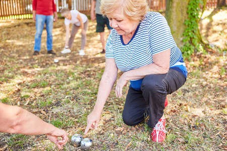 Seniors measure the distance between the balls while playing boules as a competition or hobbyの写真素材