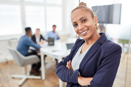 Smiling business woman as a trainee or young boss in front of her start-up team