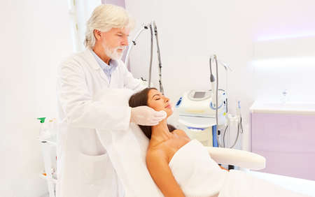Dermatologist or beautician professionally cleaning the skin of a young woman