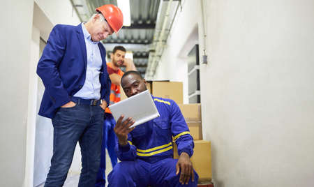 Warehouse clerk and entrepreneur at the tablet computer check the inventory in the warehouse
