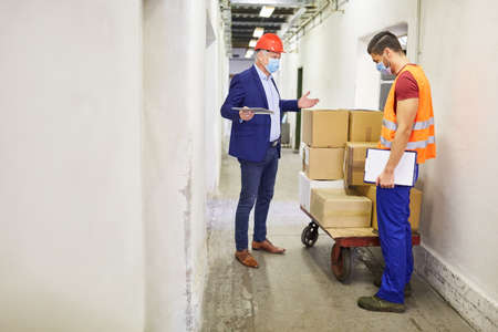 Entrepreneur and warehouse clerk check a delivery of goods in the shipping company or factory