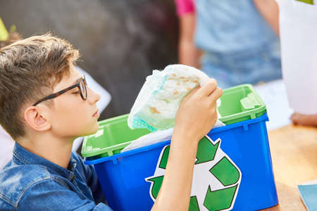 Boy with plastic waste in the ecological holiday camp during a waste recycling campaign