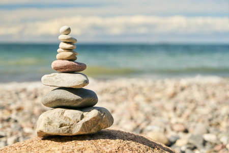 Stack of stones as a zen and balance concept on the beach by the seaの写真素材