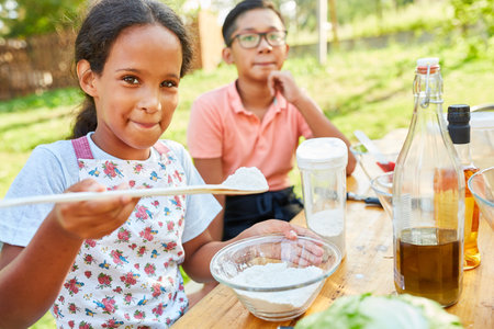Children learn to cook healthily and prepare salad in the nutrition course at the summer campの写真素材