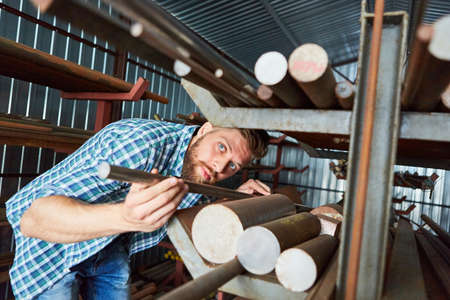 Worker as warehouse clerk during inventory control in the material warehouse of the factory or...