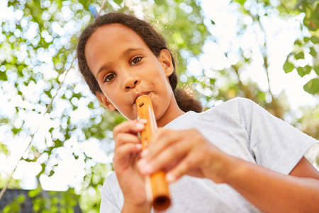 Girls with music talent playing the flute practice in a class at summer campの写真素材