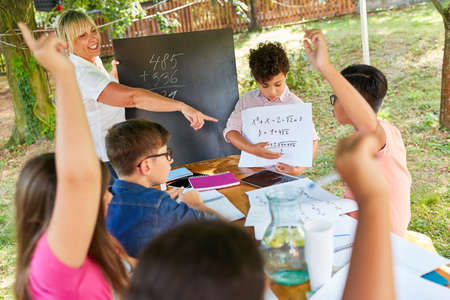 Teacher gives tutoring lessons in math for children in the summer school vacation courseの写真素材