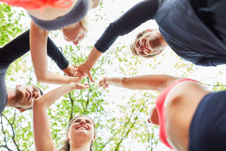 Young people giving high five for collaboration and team building in natureの写真素材