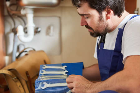 Plumber or plumber from the emergency service with tools to repair the installation