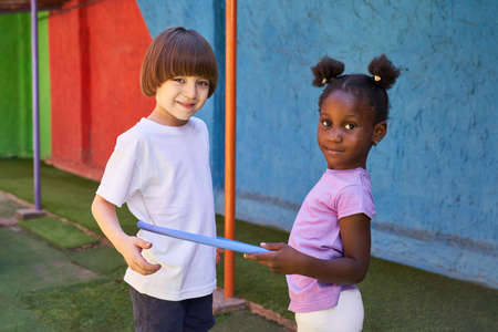 Two children play with a hoop during children's gymnastics in the international kindergarten
