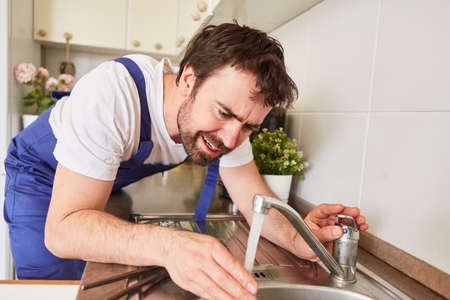 Plumber or do-it-yourselfer controls water flow at the kitchen sink tap