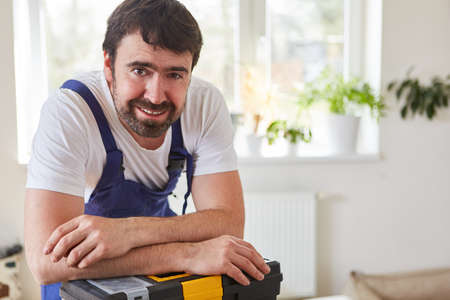 Smiling handyman or handyman draws on his toolboxの写真素材
