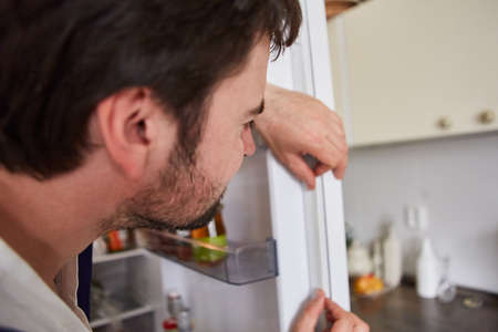 Do-it-yourselfer replacing the defective seal on the refrigerator doorの写真素材