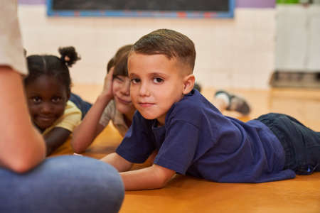 Children as friends play together on the floor in international kindergartenの写真素材