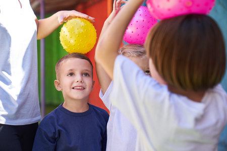 Children have fun playing ball outside in front of kindergarten in physical education classの写真素材