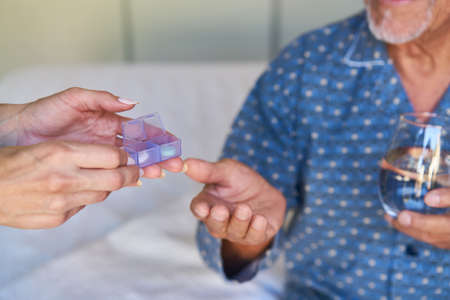 Distribution of tablets from the tablet dispenser to a sick senior patient