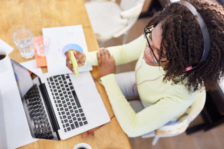 African business woman at the computer during video conference with notes for scheduling