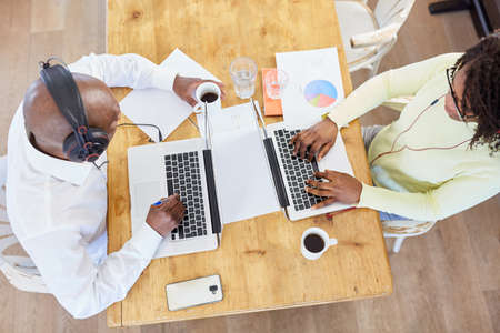 Young couple working online as a business team on laptop computer at home in the living room