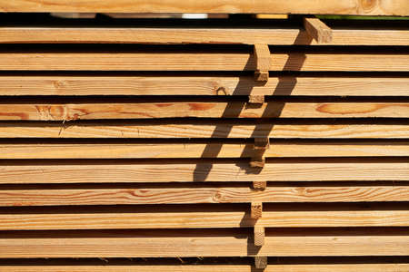Wooden beams and planks as a stack for storage in a workshop