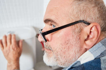 Man as a craftsman or do-it-yourselfer assembling or repairing the cistern in the toiletの写真素材