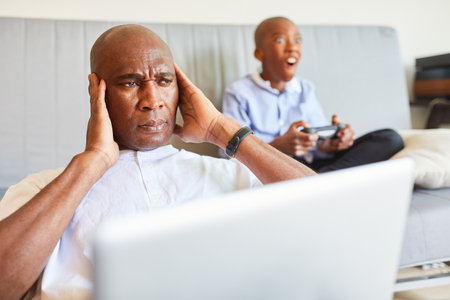 Home office father struggles with child noise in living room
