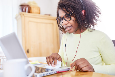 African business woman with headphones on laptop computer during a video conference online
