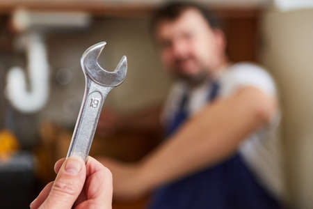 Hand holds wrench as a plumber's hand tool for installation and assemblyの写真素材