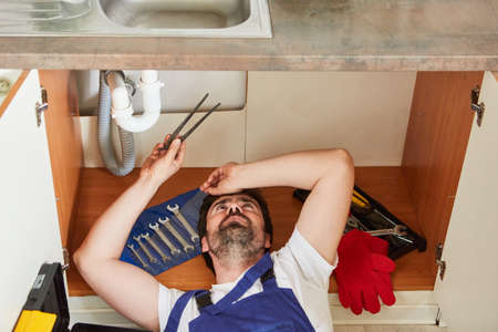 Do-it-yourselfers or plumbers repair the defective sink in the kitchenの写真素材