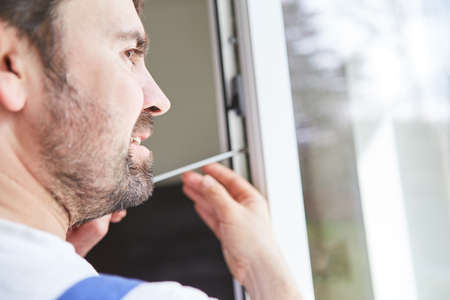 Craftsmen from a specialist company or do-it-yourselfer assemble and adjust the windowの写真素材